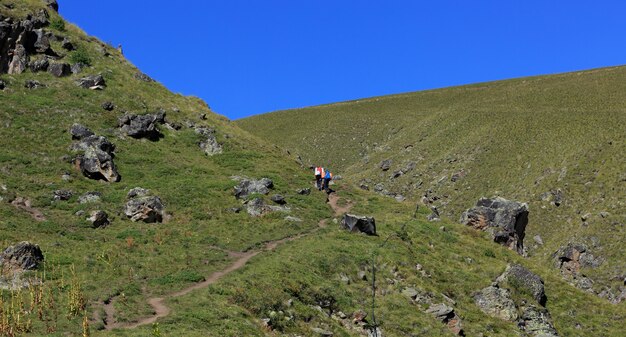 Touristen mit Rucksäcken auf einem Bergweg