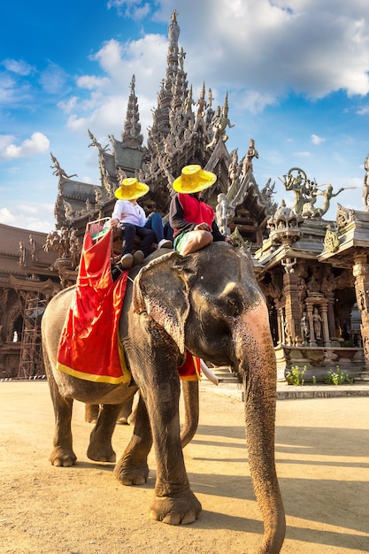 Touristen reiten Elefanten um das Heiligtum der Wahrheit in Pattaya, Thailand