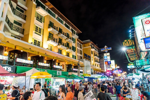 Touristen und Einheimische gehen entlang der beliebten Backpacker Destination Khaosarn