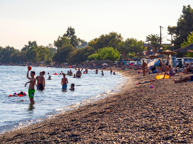 Touristen und Urlauber schwimmen im Ägäischen Meer und entspannen sich an einem Sommertag in Griechenland am Strand