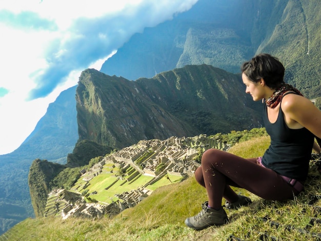 Touristenfrau, die in der Zitadelle von Machu Picchu Huayna Picchu-Berg in Cusco Peru aufwirft