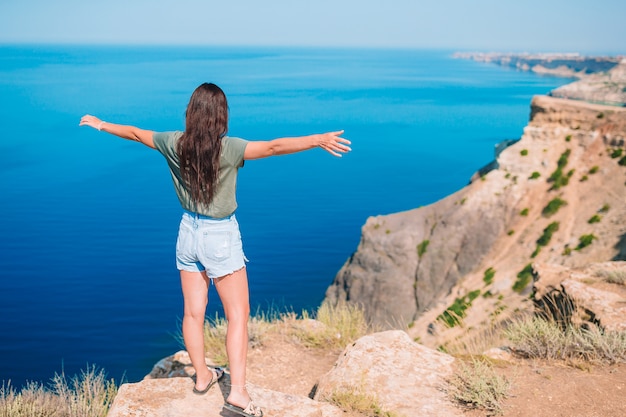 Touristenfrau im Freien am Rande der Klippenküste