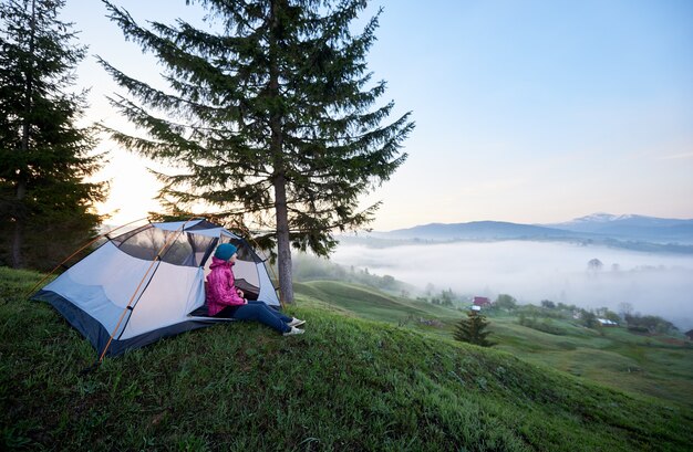 Touristenmädchen, das allein im Eingang des Touristenzeltes sitzt