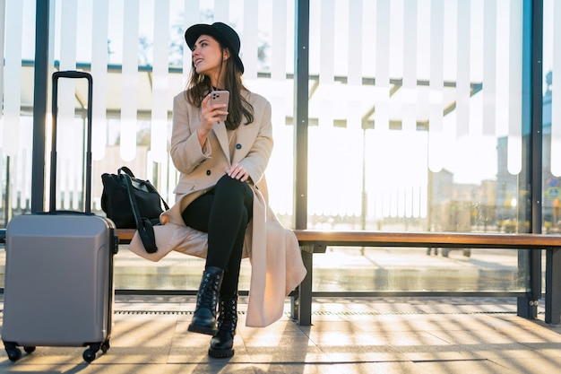 Touristenmädchen mit Smartphone am öffentlichen Verkehr.