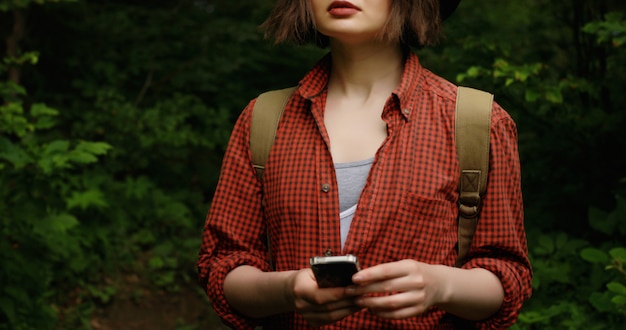 Touristenmädchen mit Telefon und Rucksack