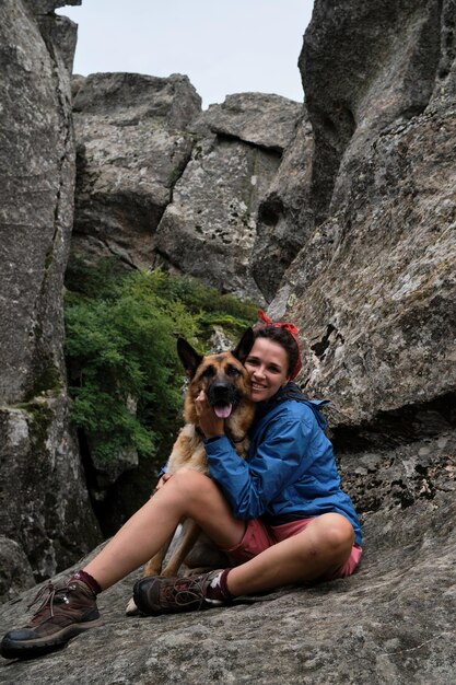 Touristin auf Bergwanderung in blauer Jacke und Stiefeln Wandern in den Bergen mit Deutscher Schäferhund