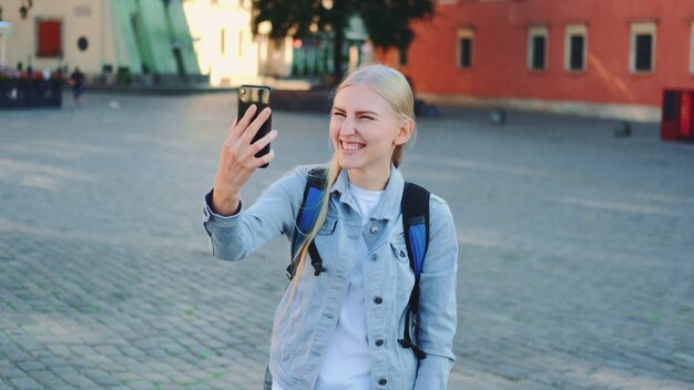 Touristin, die Videoanruf auf Smartphone vom Ort ihres Besuchs macht. Sightseeing in der schönen europäischen Stadt.