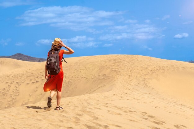 Touristin in einem roten Kleid genießt die Dünen von Maspalomas Gran Canaria Kanarische Inseln