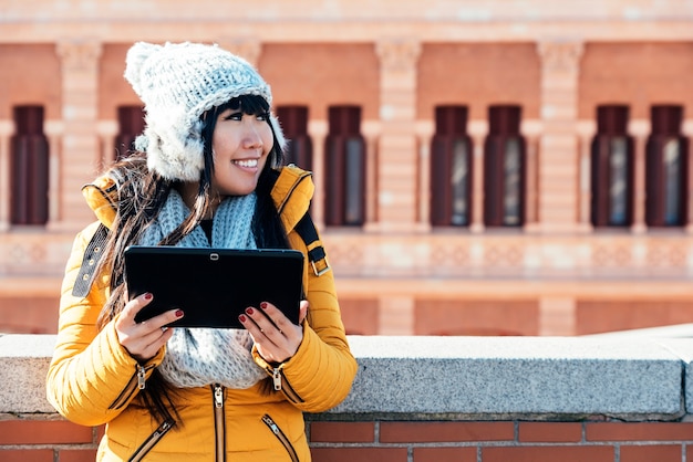 Touristische asiatische Frau mit Tablet in der europäischen Straße. Tourismus-Konzept.