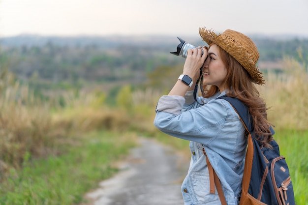 Touristische Frau, die Foto mit ihrer Kamera in der Natur macht