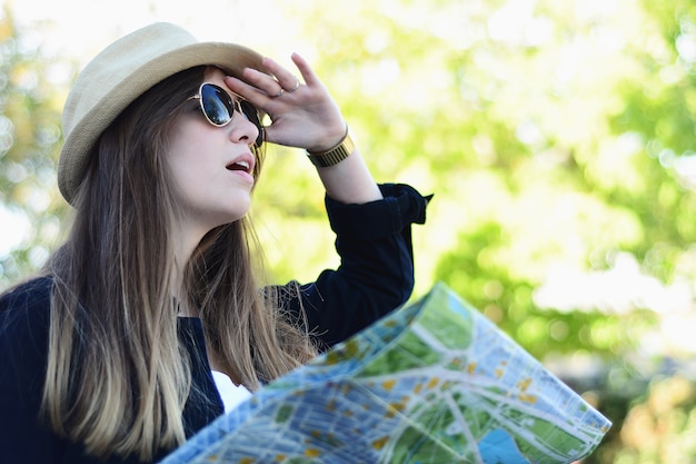 Foto touristische frau, die vorwärts mit karte schaut