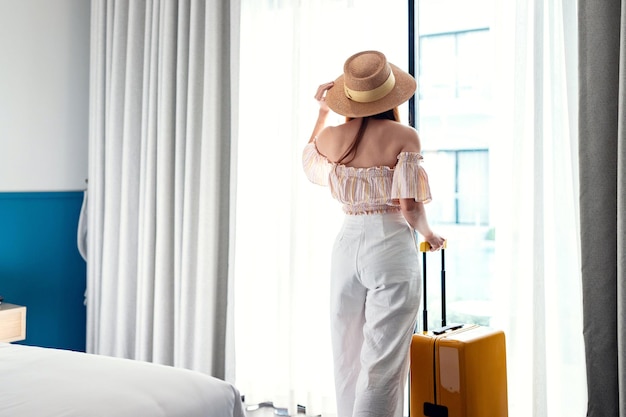 Foto touristische frau mit gepäck im hotel nach dem check-in