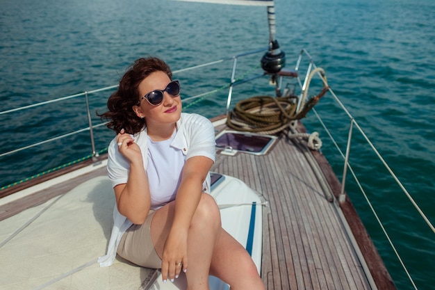 Touristische Reisende mit Sonnenbrille an einem Sommertag auf einer Yacht im Meer