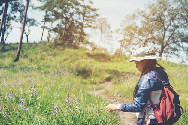 Touristische Spur, die im Wald Traveller Woman mit dem Rucksack den Berg kreuzend wandert