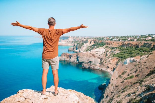 Touristischer Mann im Freien am Rande der Klippenküste