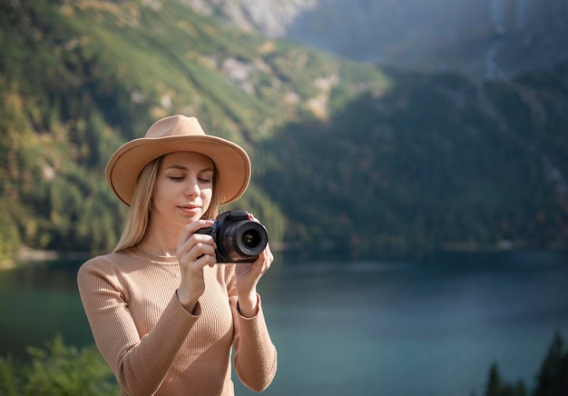 Touristischer Reisender des Fotografen, der auf grüner Spitze auf Berg steht