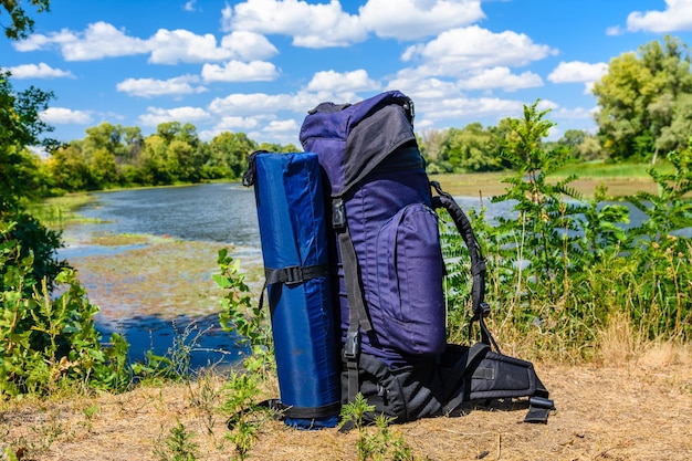 Touristischer Rucksack am Ufer des Flusses