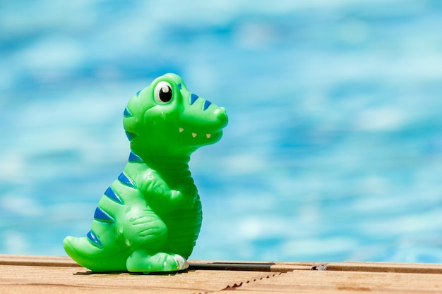 Foto toy dino de pie en la piscina en un día soleado