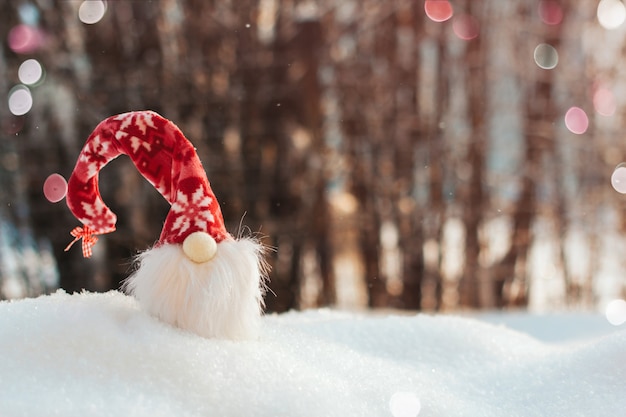 Toy Gnome in einem roten Hut im Schnee. Weihnachten textfreiraum