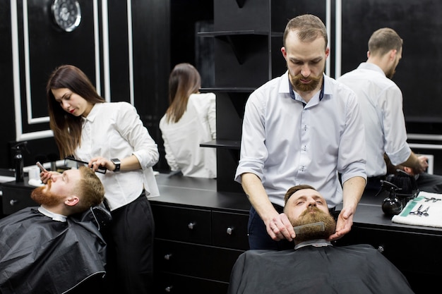 Trabaja en una barbería. Dos maestros en acción.