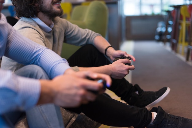 Trabaja duro juega duro. Trabajadores jugando juegos de computadora en la oficina de inicio creativo