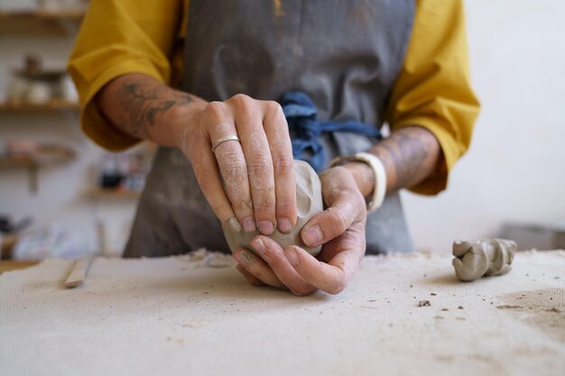 Trabaja con tus manos artista mujer moldeando arcilla cruda para esculpir y dar forma a cerámica o cerámica.