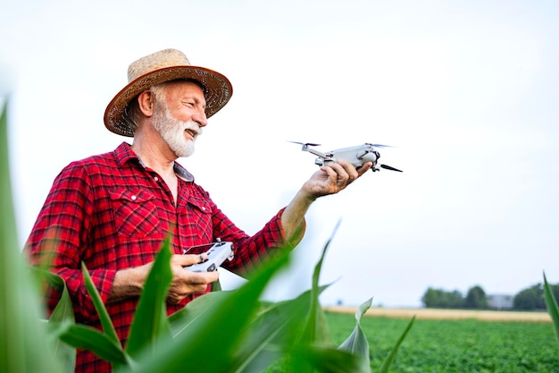 Trabajador agrícola con control remoto y drones para monitorear cultivos en el campo