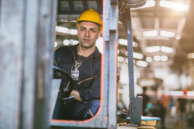 Foto trabajador de almacén masculino del personal del conductor de la carretilla elevadora que trabaja en el centro de almacenamiento de inventario de carga de la fábrica de logística