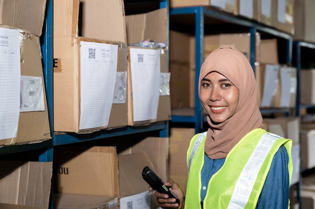 Trabajador de almacén musulmán Islam asiático hacer inventario en almacén de distribución