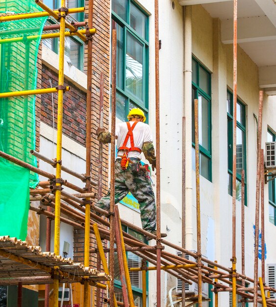 Trabajador de andamios reparando el edificio.