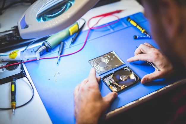 Trabajador arreglando disco HDD en taller