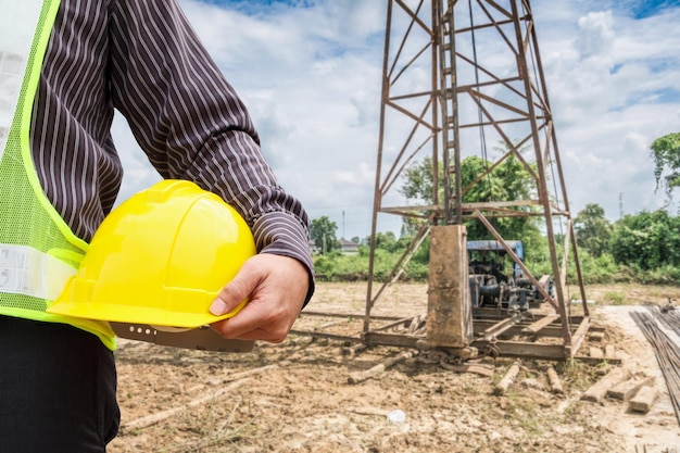 Trabajador asiático del ingeniero de la construcción del hombre de negocios en el sitio de construcción de la casa