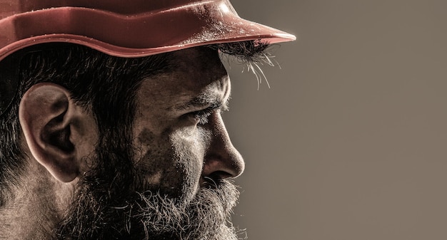 Trabajador barbudo con barba en casco de construcción o casco. Constructores de hombres, industria. Constructor en casco, capataz o reparador en el casco.