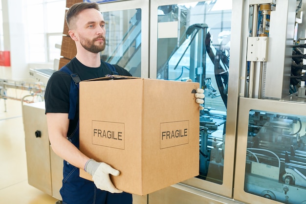 Trabajador barbudo con caja de cartón