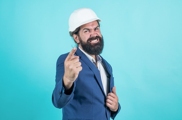 Trabajador barbudo. usted es el próximo. Arquitecto maduro feliz o agresivo en casco. brutal hombre barbudo trabaja en el sitio de construcción. trabajando en proyecto. concepto de construcción. constructor o ingeniero en casco.