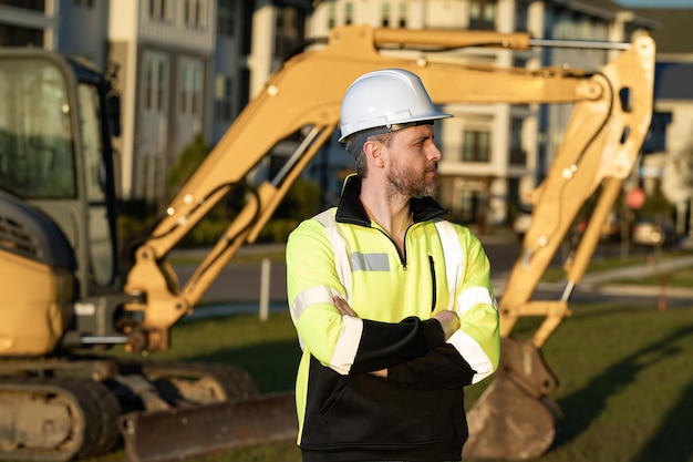 Trabajador con bulldozer en la construcción del sitio Trabajador de excavadora de hombre Trabajador de conductor de construcción con excavadora en el fondo Trabajador de la construcción con tractor o vehículo de construcción en el edificio