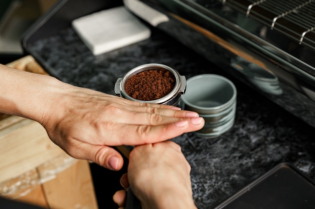 Trabajador de cafetería mujer preparando café en máquina de café profesional