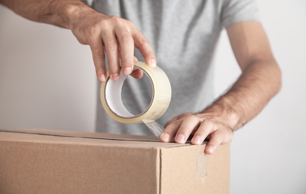 Trabajador con caja de cartón de sellado de cinta