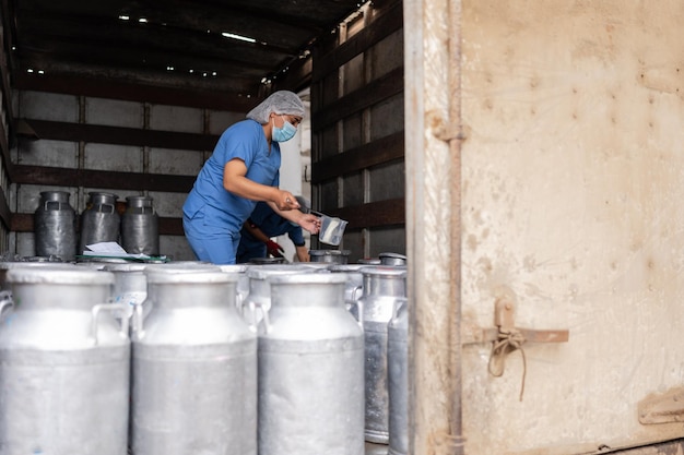 Foto trabajador en un camión tomando muestras de leche