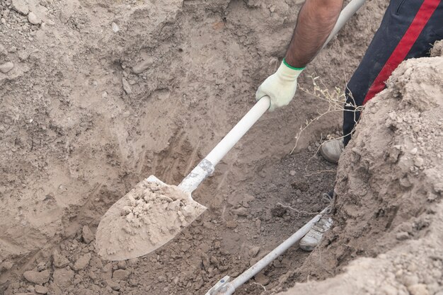 Trabajador caucásico cavando un agujero.