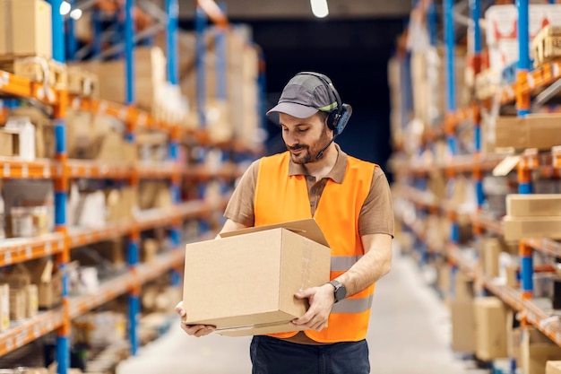 Un trabajador del centro de entrega sostiene la caja con el envío y la prepara para la entrega.