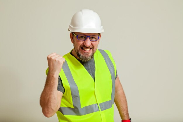 Trabajador con chaleco y casco blanco.