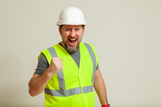 Trabajador con chaleco y casco blanco.