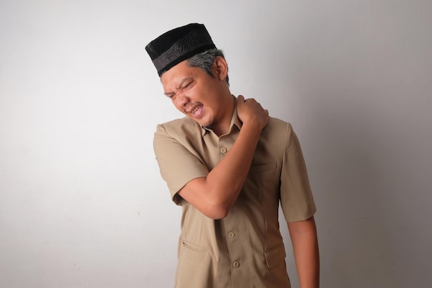 Trabajador civil indonesio cansado que sufre rigidez en el hombro