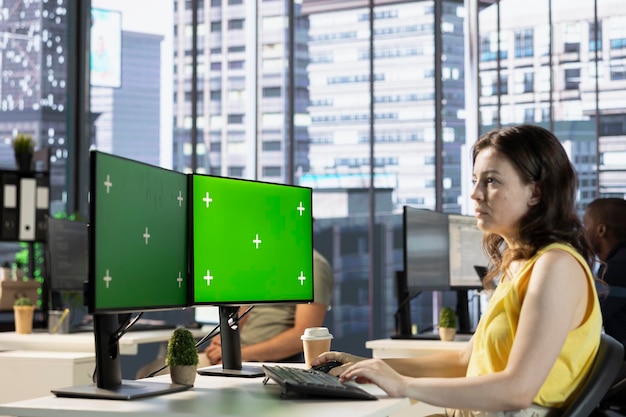 Trabajador de la compañía haciendo investigación para un proyecto de equipo en una PC de pantalla verde