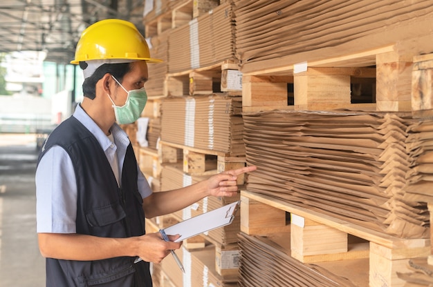 Trabajador comprobando el inventario de materias primas en la fábrica.