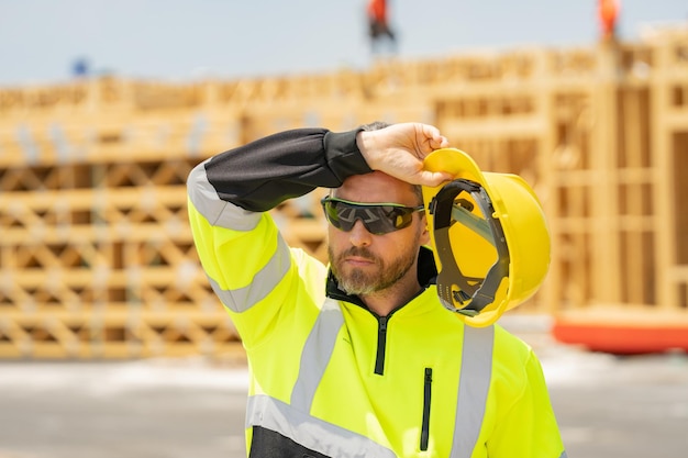 Trabajador de concepto de trabajo duro de constructor cansado en la construcción de uniformes en la construcción de fondo de construcción de edificios