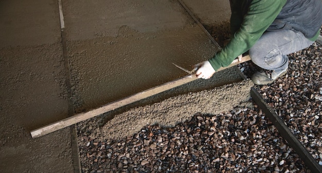 Trabajador de la construcción alinea piso de solera de hormigón