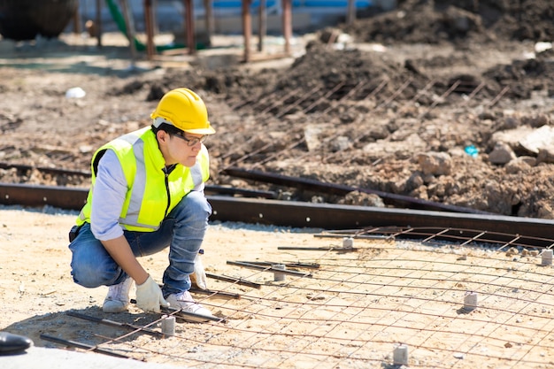 Trabajador de la construcción asiática en obra. fabricación de barra de refuerzo de acero