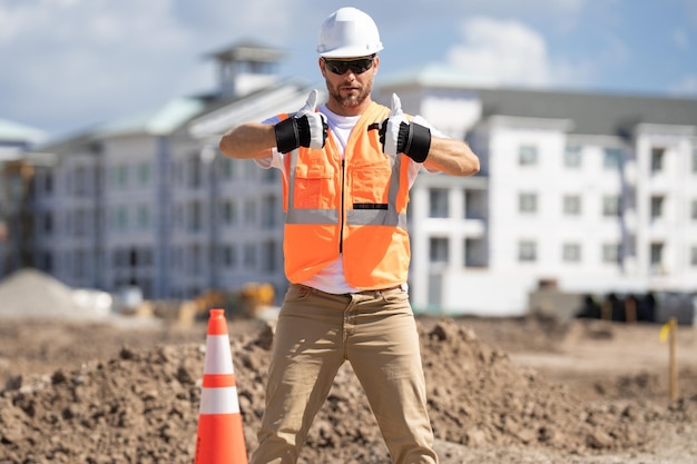 Trabajador de la construcción con casco de seguridad en el sitio de construcción ingeniero trabajador en puerto uniforme constructor